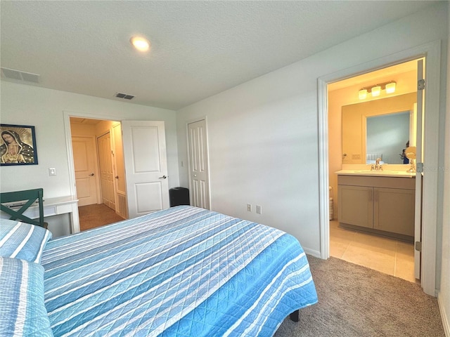 6253 Whetstone Ct, Palmetto, FL 34221 - bedroom with light colored carpet, ensuite bathroom, and a textured ceiling