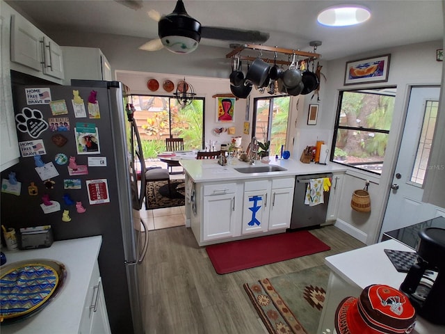 2411 Quail Ct, Bradenton, FL 34209 - kitchen featuring stainless steel appliances, white cabinetry, wood finished floors, light countertops, and a peninsula
