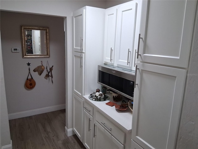2411 Quail Ct, Bradenton, FL 34209 - kitchen featuring stainless steel microwave, dark wood-style flooring, white cabinetry, and light countertops