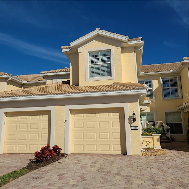 1251 Burgos Dr Unit 303, Sarasota, FL 34238 - multi unit property featuring decorative driveway, a tile roof, stucco siding, and an attached garage
