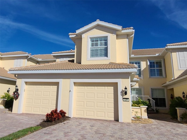 1251 Burgos Dr Unit 303, Sarasota, FL 34238 - view of property with decorative driveway, a tile roof, and stucco siding