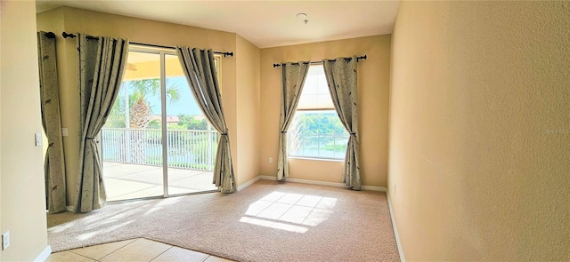 1251 Burgos Dr Unit 303, Sarasota, FL 34238 - tiled spare room with carpet and a textured wall
