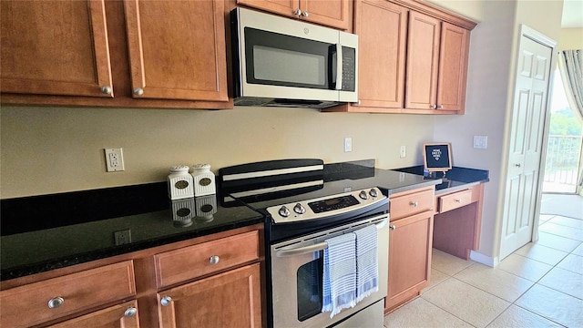 1251 Burgos Dr Unit 303, Sarasota, FL 34238 - kitchen featuring appliances with stainless steel finishes, light tile patterned flooring, and brown cabinets