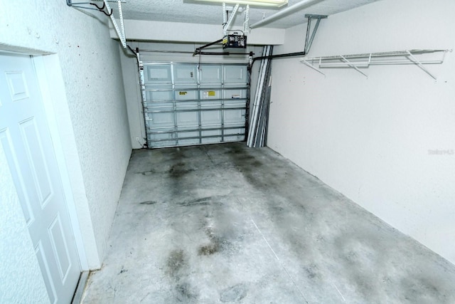 1251 Burgos Dr Unit 303, Sarasota, FL 34238 - garage featuring a garage door opener and a textured wall