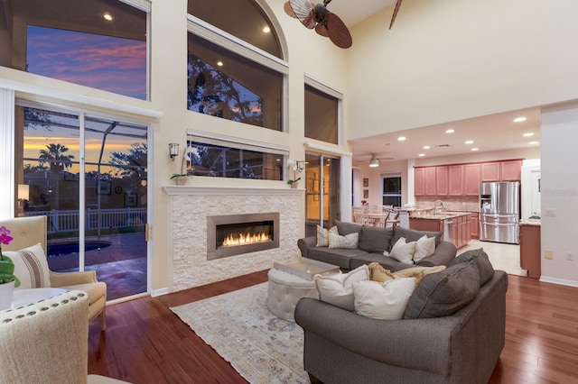 4410 67th Avenue Cir E, Sarasota, FL 34243 - living room featuring a ceiling fan, dark wood-type flooring, a fireplace, a high ceiling, and recessed lighting