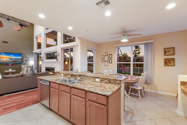4410 67th Avenue Cir E, Sarasota, FL 34243 - kitchen featuring dishwasher, ceiling fan, light tile patterned floors, a lit fireplace, and light stone countertops