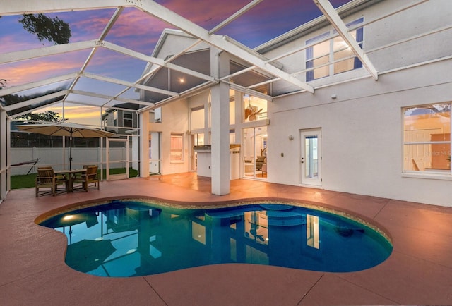 4410 67th Avenue Cir E, Sarasota, FL 34243 - pool at dusk featuring a patio area, a lanai, and an outdoor kitchen