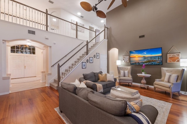 4410 67th Avenue Cir E, Sarasota, FL 34243 - living room with arched walkways, a high ceiling, ceiling fan, stairs, and wood finished floors