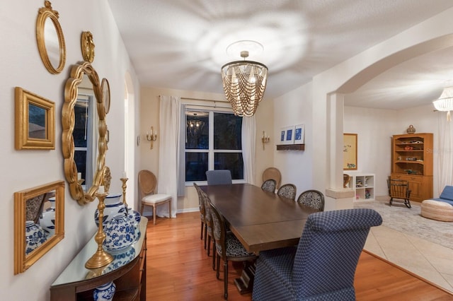4410 67th Avenue Cir E, Sarasota, FL 34243 - dining room featuring a chandelier, arched walkways, and wood finished floors