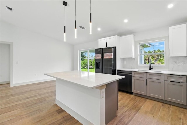 2692 Pretzel Ln, North Port, FL 34286 - kitchen featuring black dishwasher, fridge with ice dispenser, light wood-type flooring, healthy amount of natural light, and recessed lighting