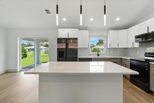 2692 Pretzel Ln, North Port, FL 34286 - kitchen featuring black appliances, decorative backsplash, light stone countertops, light wood-type flooring, and recessed lighting
