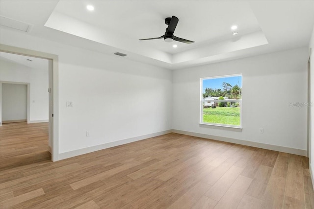 2692 Pretzel Ln, North Port, FL 34286 - spare room featuring a tray ceiling, light wood finished floors, recessed lighting, ceiling fan, and attic access