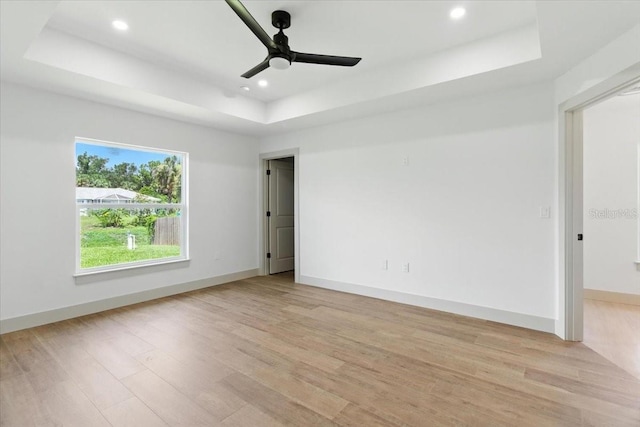 2692 Pretzel Ln, North Port, FL 34286 - spare room featuring a tray ceiling, light wood-type flooring, a ceiling fan, and recessed lighting