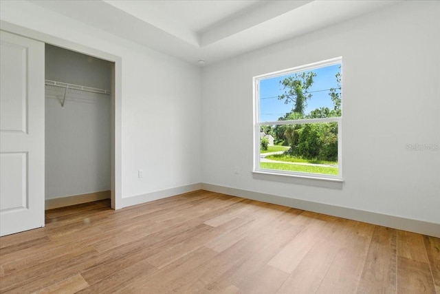 2692 Pretzel Ln, North Port, FL 34286 - unfurnished bedroom featuring light wood-style flooring, a closet, and a raised ceiling