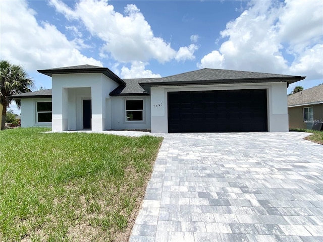 2692 Pretzel Ln, North Port, FL 34286 - prairie-style house featuring stucco siding, an attached garage, a front lawn, and decorative driveway