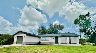 5009 Jody Ave, North Port, FL 34288 - rear view of property with a garage, a lawn, and concrete driveway