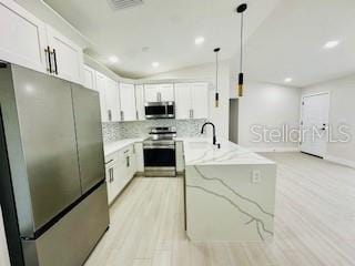 5009 Jody Ave, North Port, FL 34288 - kitchen with appliances with stainless steel finishes, a peninsula, light wood-style floors, light stone counters, and tasteful backsplash