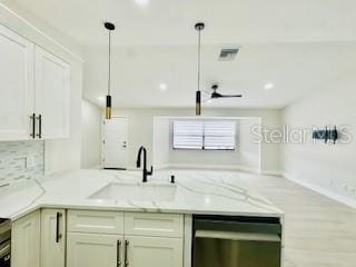5009 Jody Ave, North Port, FL 34288 - kitchen featuring stainless steel dishwasher, light stone counters, a peninsula, backsplash, and ceiling fan