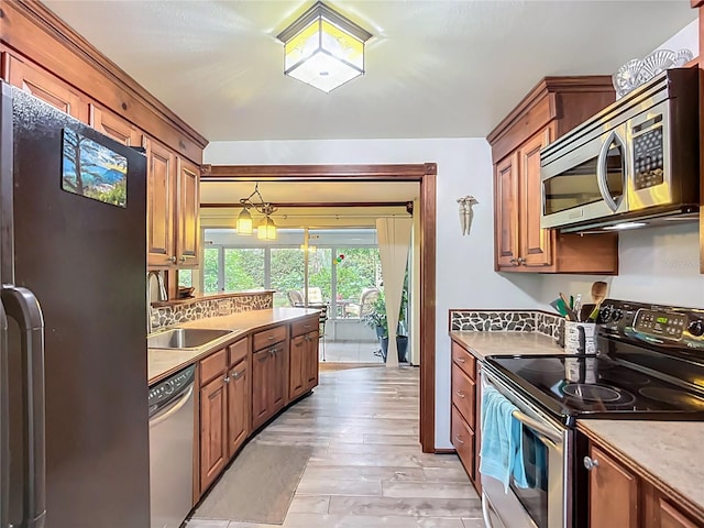 408 67th Ave W, Bradenton, FL 34207 - kitchen featuring appliances with stainless steel finishes, light wood-style flooring, light countertops, and brown cabinetry