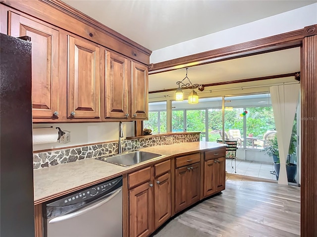 408 67th Ave W, Bradenton, FL 34207 - kitchen with stainless steel dishwasher, freestanding refrigerator, light wood-style flooring, brown cabinets, and decorative light fixtures