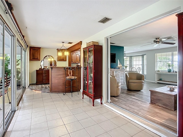 408 67th Ave W, Bradenton, FL 34207 - kitchen with a peninsula, a breakfast bar, ceiling fan, decorative light fixtures, and open floor plan