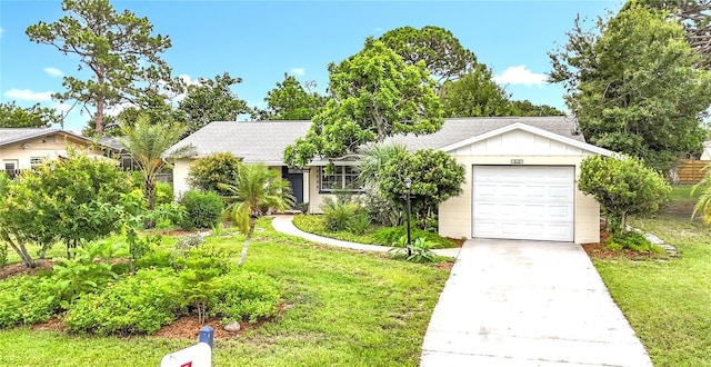 408 67th Ave W, Bradenton, FL 34207 - ranch-style house with board and batten siding, a front yard, concrete driveway, a shingled roof, and an attached garage
