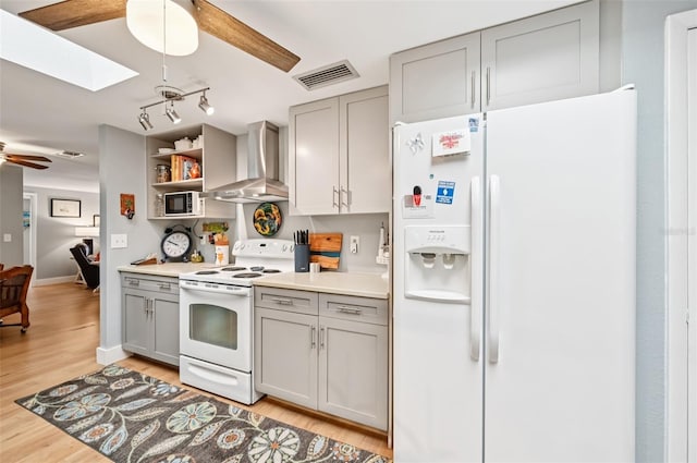 6002 34th Ave W, Bradenton, FL 34209 - kitchen with white appliances, wall chimney exhaust hood, gray cabinetry, ceiling fan, and a skylight