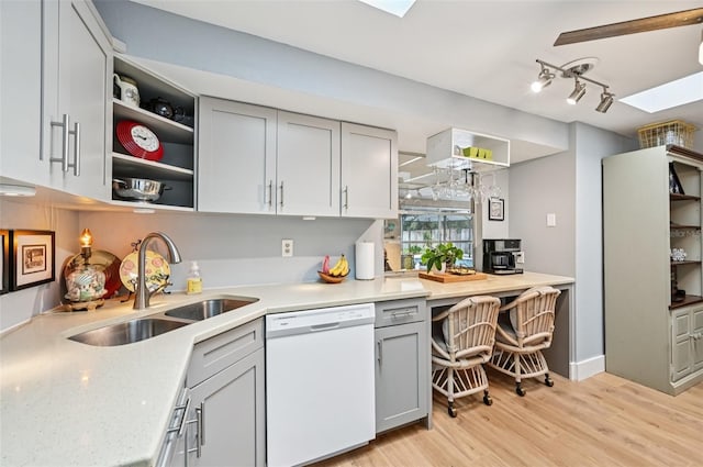 6002 34th Ave W, Bradenton, FL 34209 - kitchen with white dishwasher, open shelves, a skylight, and light wood-style flooring