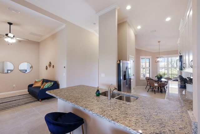 13714 Messina Loop Unit 202, Bradenton, FL 34211 - kitchen featuring stainless steel refrigerator with ice dispenser, crown molding, white cabinets, a peninsula, and light stone counters