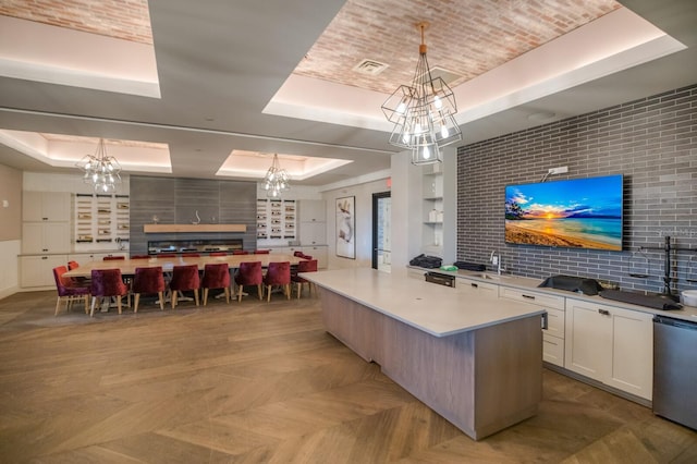13714 Messina Loop Unit 202, Bradenton, FL 34211 - kitchen featuring a raised ceiling, a chandelier, and white cabinets