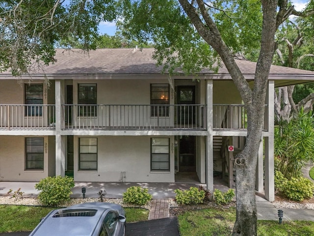 3003 Quail Holw Unit 10, Sarasota, FL 34235 - back of property featuring stucco siding, a balcony, and a shingled roof