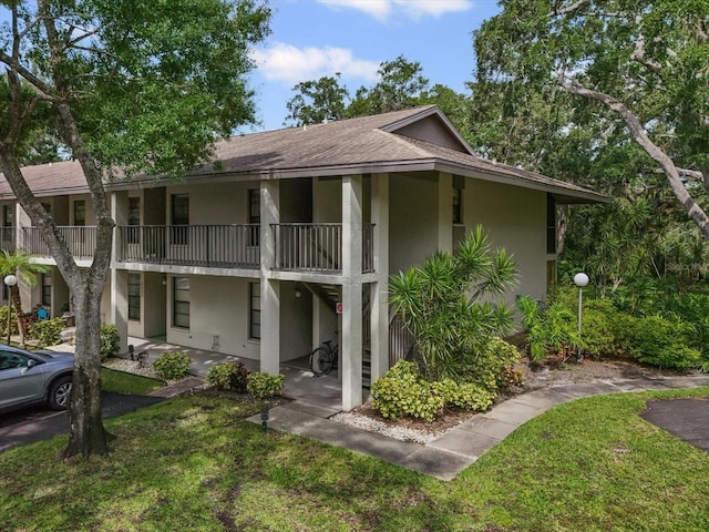 3003 Quail Holw Unit 10, Sarasota, FL 34235 - view of front of home with stucco siding, a shingled roof, and a front yard