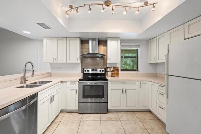 3003 Quail Holw Unit 10, Sarasota, FL 34235 - kitchen featuring appliances with stainless steel finishes, wall chimney range hood, a raised ceiling, light countertops, and tasteful backsplash