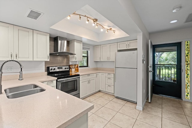 3003 Quail Holw Unit 10, Sarasota, FL 34235 - kitchen featuring freestanding refrigerator, wall chimney exhaust hood, stainless steel range with electric stovetop, light countertops, and recessed lighting