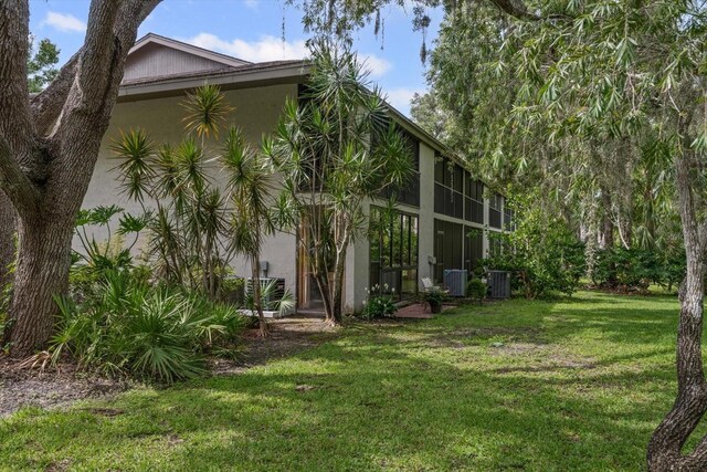 3003 Quail Holw Unit 10, Sarasota, FL 34235 - back of house featuring stucco siding and a lawn