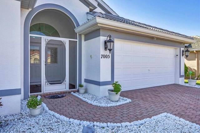 7005 Goldrush Ln, Bradenton, FL 34201 - view of exterior entry featuring stucco siding, decorative driveway, and an attached garage