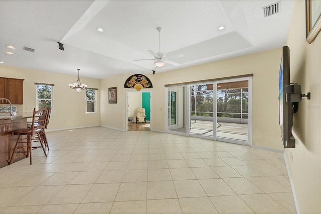 7005 Goldrush Ln, Bradenton, FL 34201 - unfurnished living room with a chandelier, a tray ceiling, ceiling fan, recessed lighting, and light tile patterned flooring