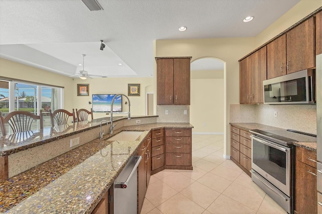 7005 Goldrush Ln, Bradenton, FL 34201 - kitchen featuring stainless steel appliances, backsplash, light tile patterned flooring, recessed lighting, and arched walkways