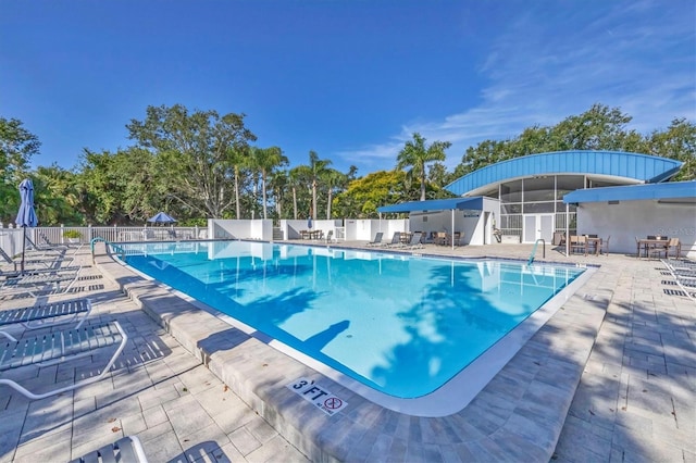 7005 Goldrush Ln, Bradenton, FL 34201 - community pool featuring a patio and view of wooded area