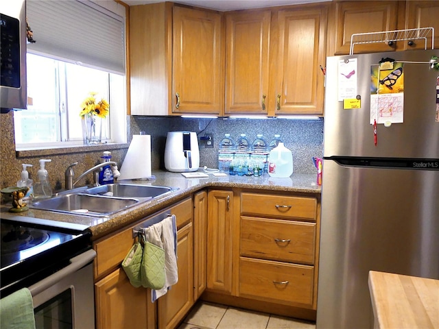1850 Sunny Dr Unit F4, Bradenton, FL 34207 - kitchen with stainless steel appliances, backsplash, light tile patterned flooring, brown cabinets, and light countertops