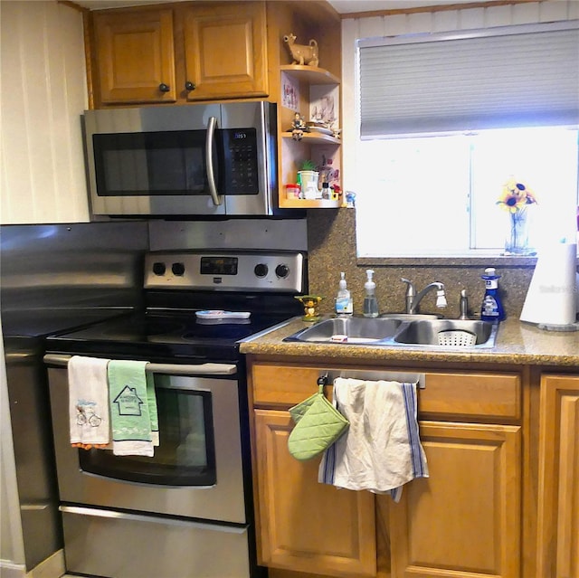 1850 Sunny Dr Unit F4, Bradenton, FL 34207 - kitchen featuring stainless steel appliances, brown cabinetry, decorative backsplash, and open shelves
