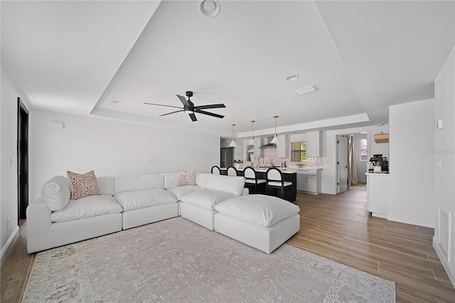 326 Randolph Rd, Venice, FL 34293 - living room featuring a raised ceiling, a ceiling fan, light wood-type flooring, and recessed lighting