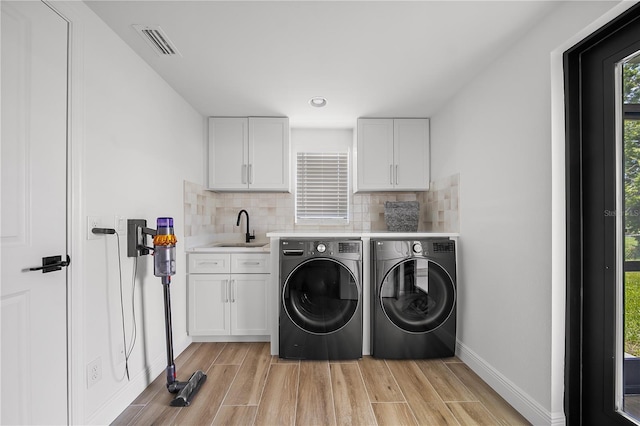 326 Randolph Rd, Venice, FL 34293 - washroom with washing machine and dryer, cabinet space, and light wood-style flooring