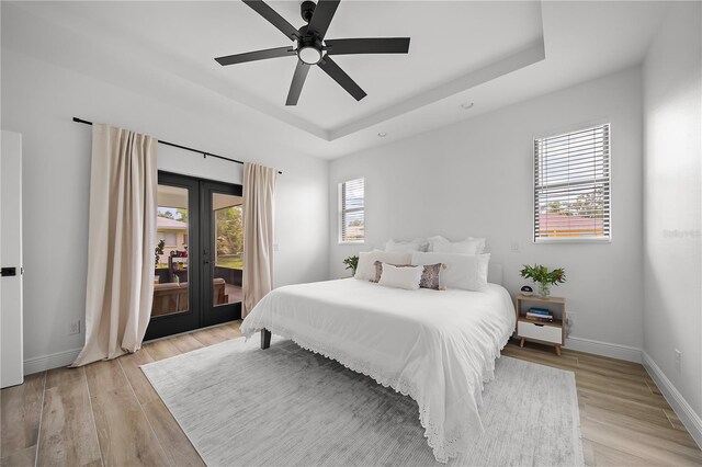 326 Randolph Rd, Venice, FL 34293 - bedroom with access to outside, french doors, light wood-type flooring, a tray ceiling, and a ceiling fan