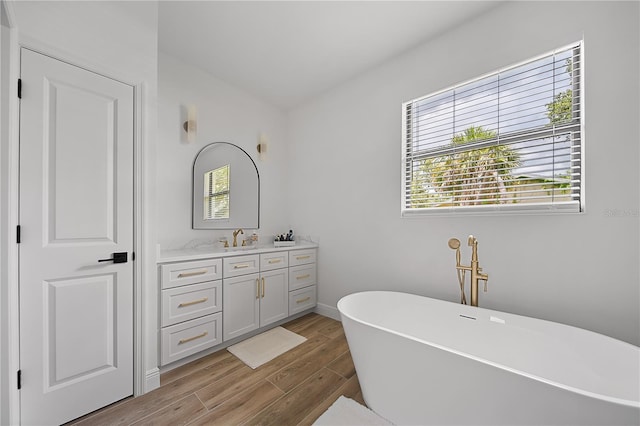 326 Randolph Rd, Venice, FL 34293 - full bath featuring vanity, a freestanding tub, wood finished floors, and healthy amount of natural light