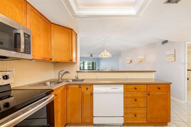 2110 Benjamin Franklin Dr Unit 301, Sarasota, FL 34236 - kitchen featuring appliances with stainless steel finishes, a peninsula, light tile patterned floors, ceiling fan, and a tray ceiling