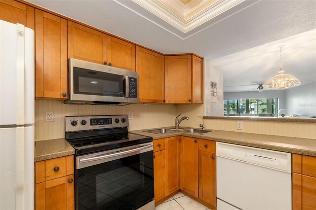 2110 Benjamin Franklin Dr Unit 301, Sarasota, FL 34236 - kitchen with appliances with stainless steel finishes, brown cabinetry, light tile patterned floors, and decorative light fixtures
