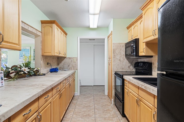 2110 Benjamin Franklin Dr Unit 301, Sarasota, FL 34236 - kitchen featuring black appliances, light brown cabinets, light countertops, decorative backsplash, and light tile patterned floors