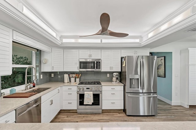 6105 45th St W, Bradenton, FL 34210 - kitchen with stainless steel appliances, crown molding, backsplash, wood finished floors, and white cabinetry