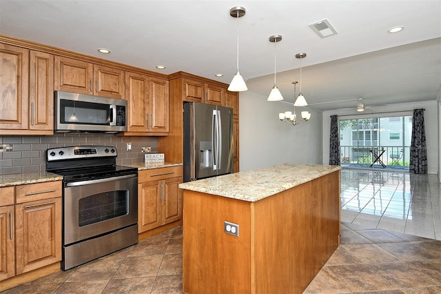 3985 Maceachen Blvd Unit 224, Sarasota, FL 34233 - kitchen featuring stainless steel appliances, brown cabinets, backsplash, a center island, and recessed lighting